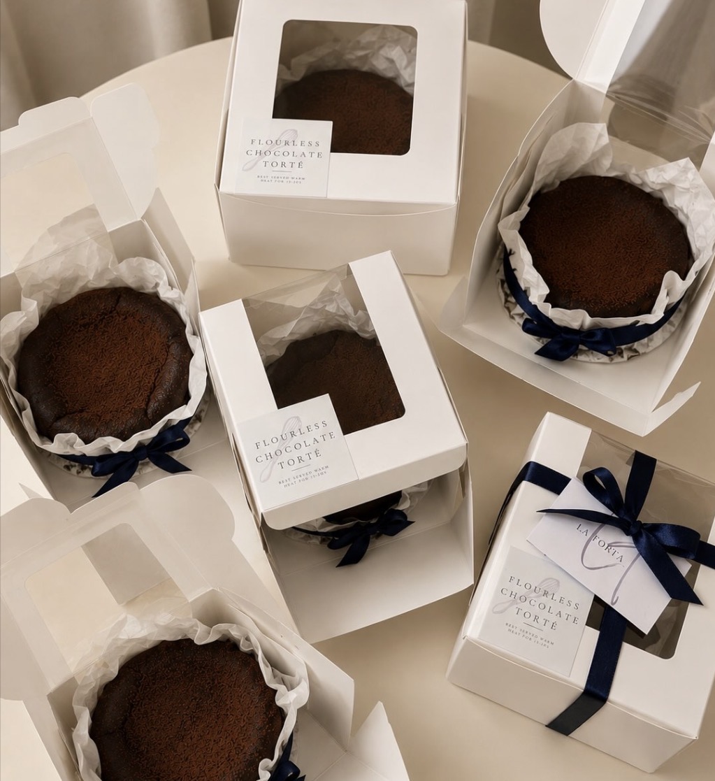 Flourless chocolate tortés boxed with navy ribbons and La Torta gift tags