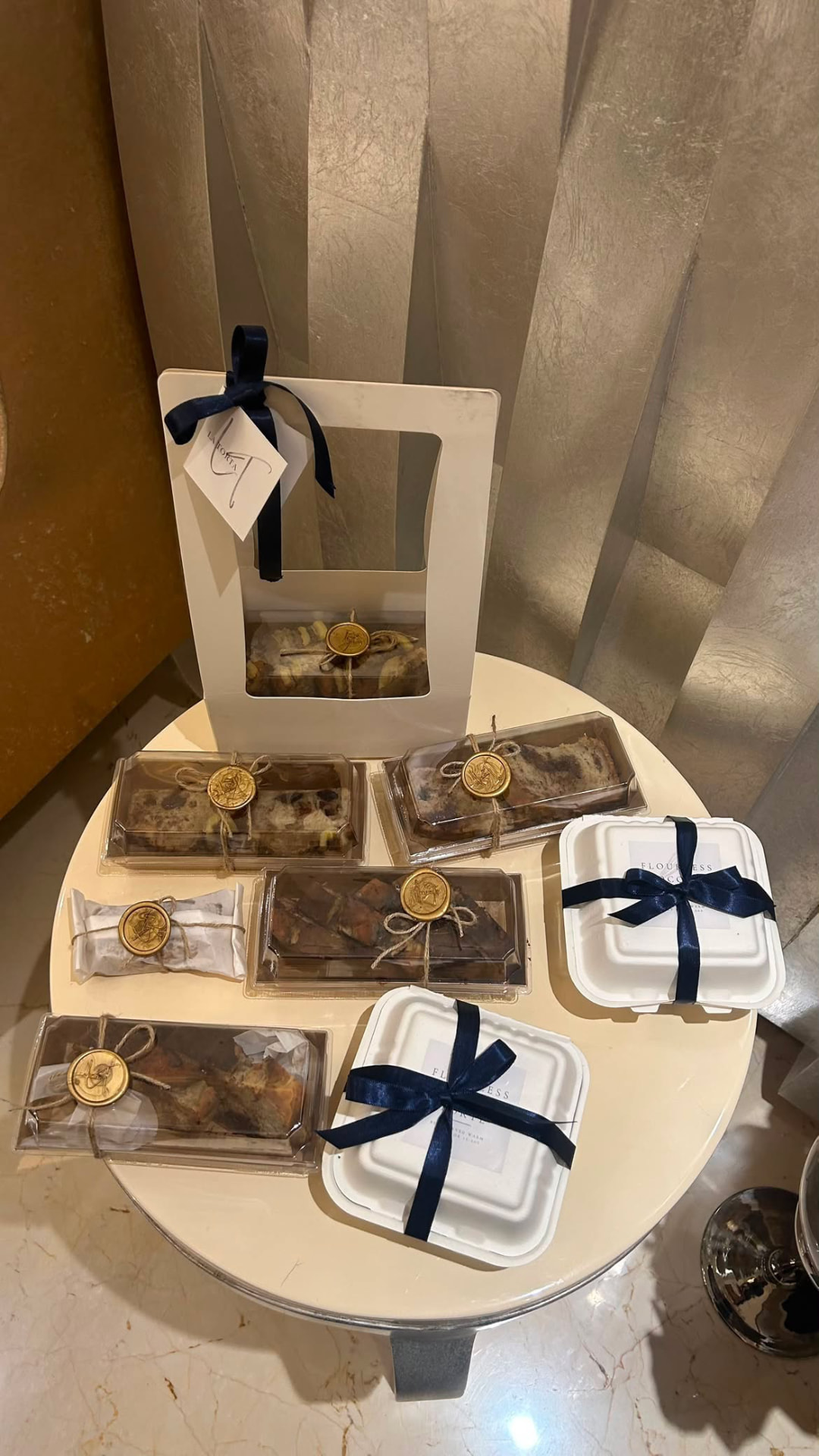 La Torta desserts boxed with navy ribbons and gold wax seals on a table